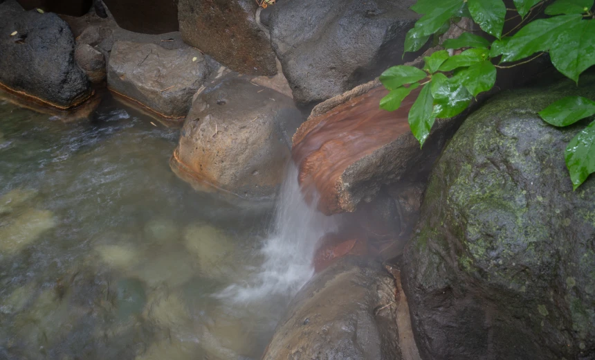 岩の間から湯が注ぐ、露天風呂